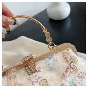 Detail der eleganten Abendtasche mit Schmetterlingsstickerei und Strass-Verschluss