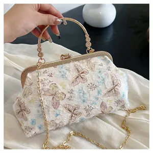 Detailansicht der eleganten Muschelabendtasche mit Schmetterlingsstickerei und Goldkette