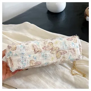 Detailansicht der eleganten Schmetterlingsstickerei und Fransen an der Abendtasche