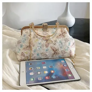 Exquisite Abendtasche mit Schmetterlingsstickerei neben einem Tablet zum Größenvergleich