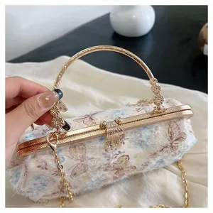 Detail der Schmetterlingsstickerei und des Strassverschlusses an Abendtasche