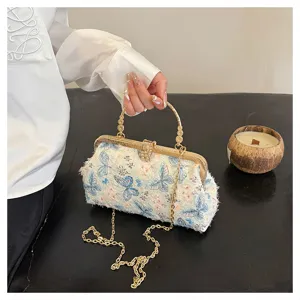 Elegante Abendtasche mit Schmetterlingsstickerei, Strassverschluss und Goldkette.