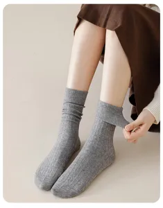 Detail shot of women's grey wool mid-tube socks featuring cable knit texture and elastic cuff.