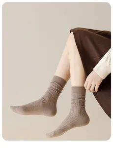 Detail shot of women's autumn winter thick warm wool cable knit mid tube socks in brown.