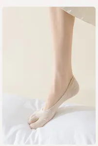Primo piano di calzini invisibili a cinque dita da donna in beige, morbidi traspiranti estivi.