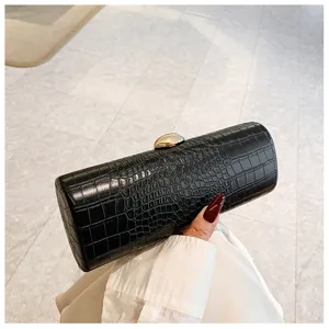 Close-up of elegant black crocodile texture baguette clutch bag with gold clasp