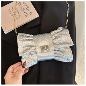 Gros plan d'une pochette nœud argentée avec des strass étincelants et une chaîne.