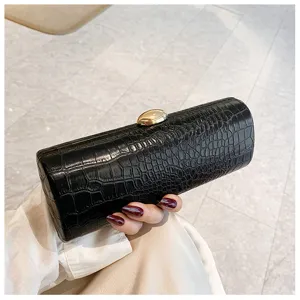 Close-up of retro black crocodile embossed baguette clutch with gold clasp.