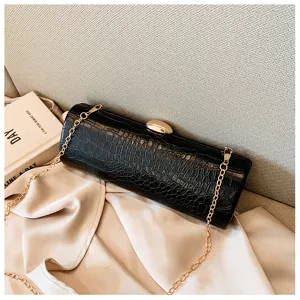 Detail view of the vintage black crocodile pattern baguette bag with a gold chain