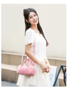 Elegante bolso Boston rosa estilo jelly llevado por una modelo asiática en un entorno urbano