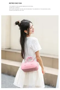 Bolso Boston de gelatina rosa llevado en bandolera por una modelo en un estilo chic