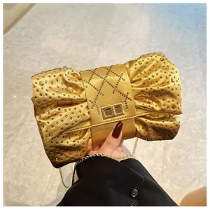 Vue détaillée de l'élégante pochette nœud dorée ornée de strass brillants de luxe