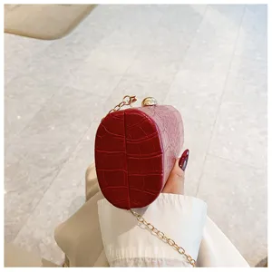 Detailed side view of a red retro crocodile texture baguette clutch with gold clasp