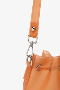 Close-up of silver metal hardware and frosted orange TPU material on a jelly bucket bag.