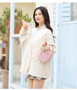 Giovane donna con una piccola borsa a mano rosa a forma di cuore con motivo trapuntato