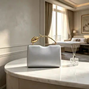 Detail view of a silver evening clutch bag featuring a unique gold tulip flower handle