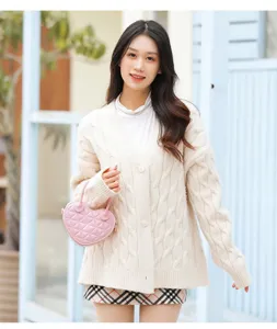 Modella con una dolce borsa a mano rosa trapuntata a forma di cuore in stile lifestyle.