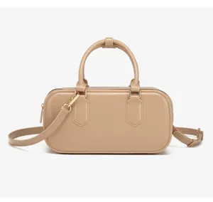 Detalle que muestra el acabado brillante y los herrajes dorados de un bolso Boston beige