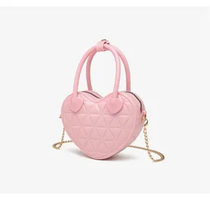 Primo piano della borsa a cuore rosa trapuntata in PVC con tracolla a catena oro.