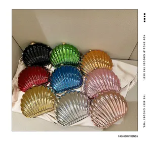 Detailed macro view of colorful shell-shaped metallic evening clutch bags on satin