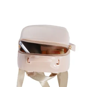 Detailed interior view of a pink glossy PVC mini shell backpack showing storage space