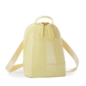 Close-up of yellow glossy PVC mini backpack with sleek shell-shaped design