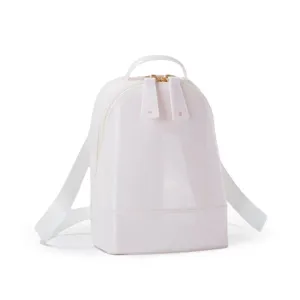 Close-up of a stylish glossy pink PVC mini backpack featuring gold-toned dual zippers