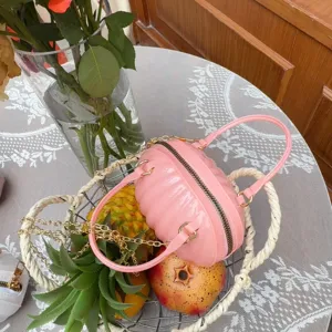 Sac créatif rose en forme de citrouille placé dans un panier de fruits avec ananas et grenade