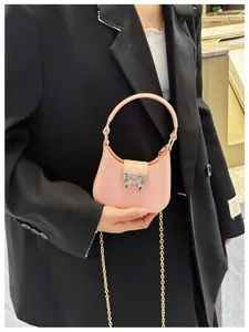 Detailed close-up of a stylish pink mini jelly bag featuring a bow accent and gold chain