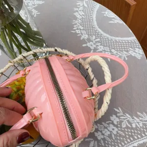 Vue détaillée du sac à main en PVC rose en forme de citrouille avec accents dorés