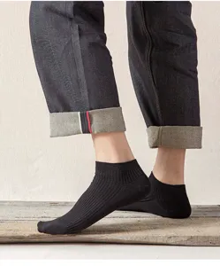 Close-up detail shot of classic black ribbed low-cut men socks displaying breathable texture.