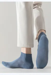 Close-up detail of blue men's low-cut breathable mesh socks with textured knit sole pattern.