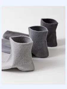 Close-up detail view of men's casual ribbed cotton short socks in solid grey tones.