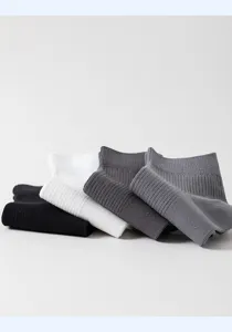Detail view of men's solid color short socks folded neatly in assorted neutral shades.