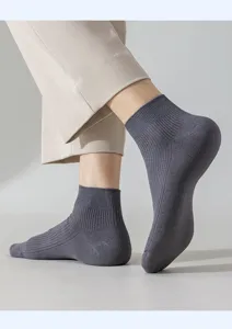 Detailed close-up shot of men's summer short ribbed socks in solid grey color on ankles.