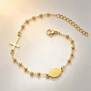 Detail view of a gold-plated stainless steel cross bracelet with religious medal pendant