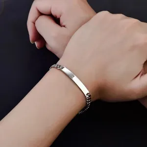 Nahaufnahme eines polierten Edelstahl-Armbands mit rechteckiger Platte am Handgelenk