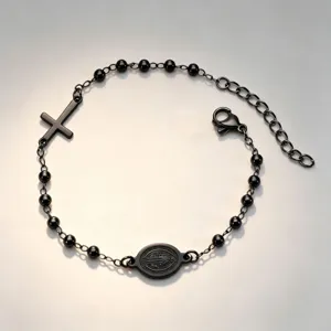 Detailed macro view of black stainless steel rosary bracelet with cross and religious medal