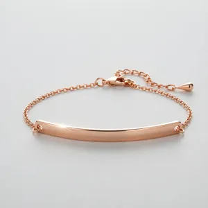 Close-up of minimalist rose gold stainless steel curved bar bracelet for engraving.