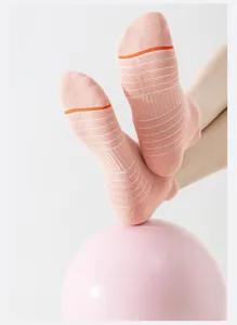 Detailed view of pink athletic sports socks with white stripes and towel bottom design.