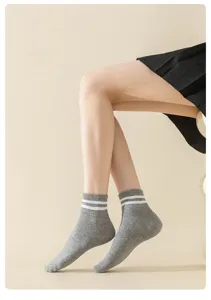 Detail shot of women's grey ankle socks featuring classic white double stripes on ribbed cuffs.