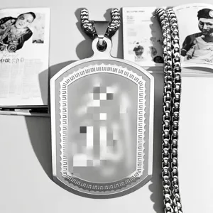 Close-up of the intricate etched patterns on a men's rectangular stainless steel pendant