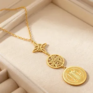 Detailaufnahme einer goldenen Edelstahlkette mit Hexenknoten und Pentagramm-Anhängern