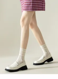 Vue detaillee de chaussettes en dentelle blanche pour femme associees avec des souliers.