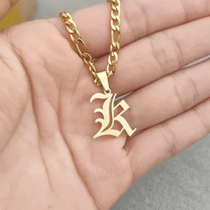 Detailed view of a vintage gold Gothic letter K pendant on a classic Figaro chain.