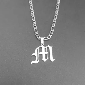 Macro view of a Gothic style letter M pendant on a silver titanium steel figaro chain