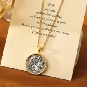 Detailansicht einer Vintage-Münz-Halskette mit goldener Kordelkette und Geschenkkarte.