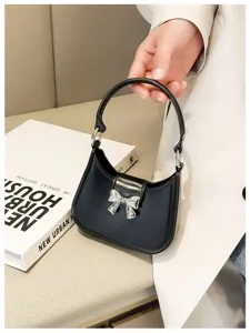 Detailed close-up of a stylish black PVC jelly handbag with a silver bow ornament.