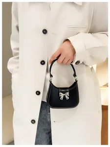 Detailed view of a stylish black PVC jelly handbag featuring a silver bow accent