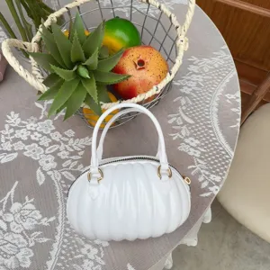 Vue détaillée d'un sac à main créatif en PVC blanc en forme de citrouille sur table